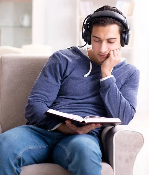 Νεαρός διαβάζει βιβλία και ακούει ακουστικά βιβλία — Φωτογραφία Αρχείου