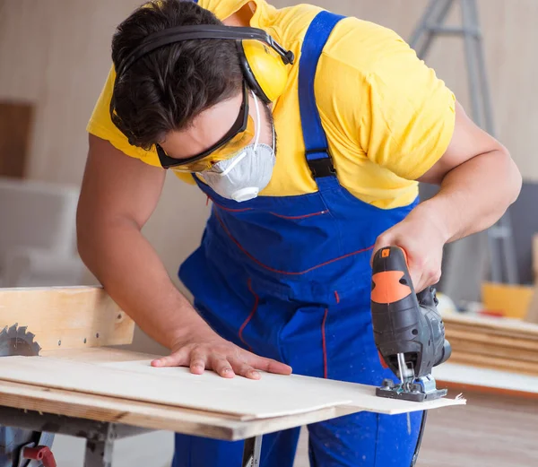 Ung reparatör snickare arbetar med en cirkelsåg — Stockfoto