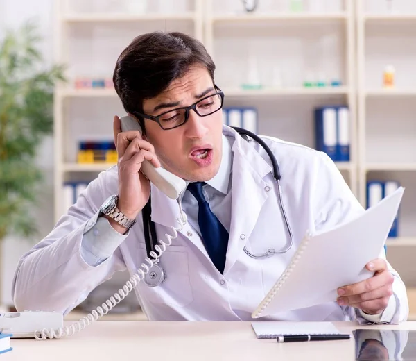 Jovem médico sentado no escritório — Fotografia de Stock