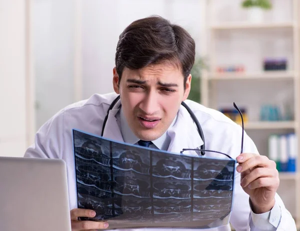 Jeune médecin regardant des images radiographiques à la clinique — Photo