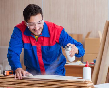 Yooung marangoz boyayla uğraşıyor.