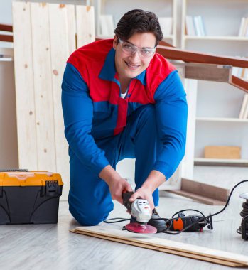 Genç marangoz ahşap kalaslarla çalışıyor.