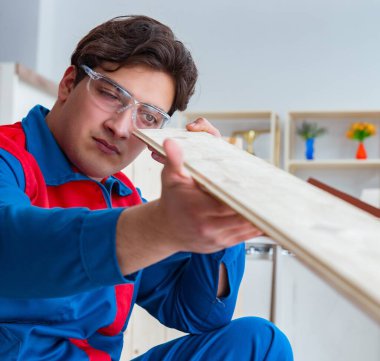 Genç marangoz ahşap kalaslarla çalışıyor.