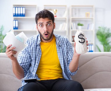 Ödeme yapması gereken faturalara kızgın bir adam.