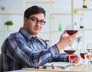 Profesyonel şarap garsonu kırmızı şarap tadıyor.