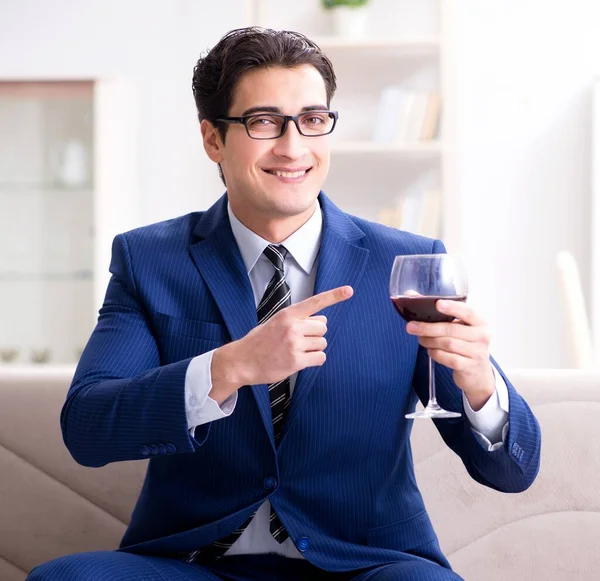 Uomo d'affari che beve vino seduto a casa — Foto Stock