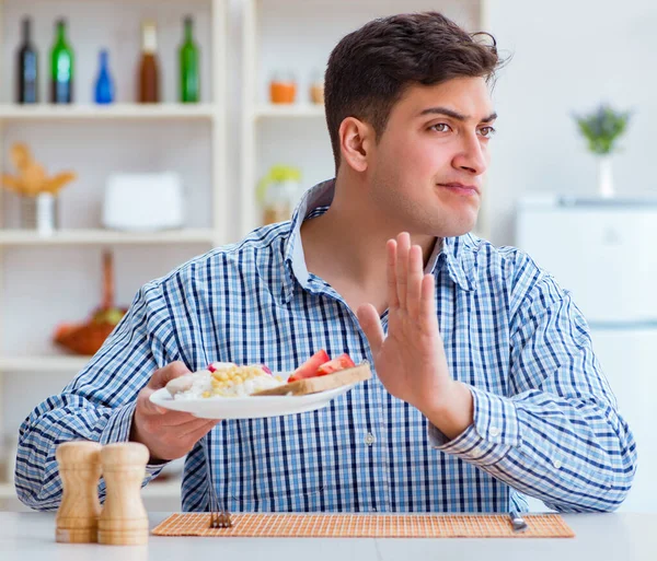Joven marido comiendo comida insípida en casa para el almuerzo — Foto de Stock