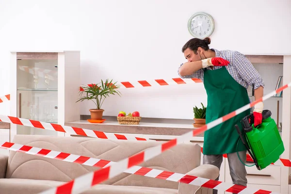 Young male sanitizer disinfecting indoors — Stock Photo, Image