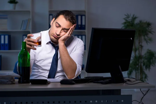 Alcohol addicted businessman working late in the office — Stock Photo, Image