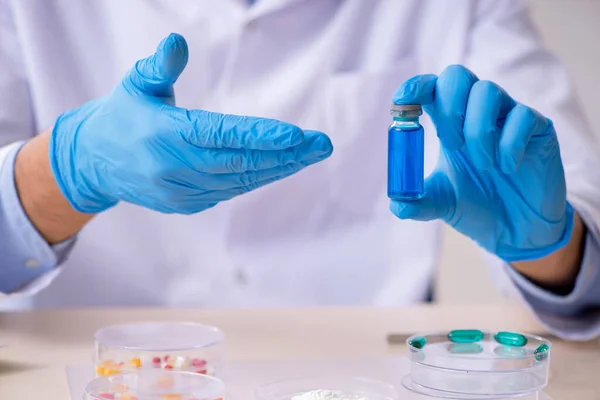 Joven asistente de laboratorio masculino en concepto de síntesis de fármacos —  Fotos de Stock