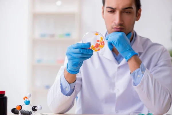 Jovem assistente de laboratório no conceito de síntese de drogas — Fotografia de Stock