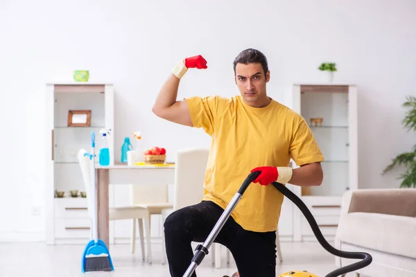 Young male contractor cleaning the house