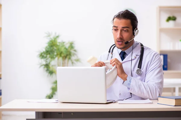 Mladý lékař naslouchá pacientovi během telemedicínského sezení — Stock fotografie