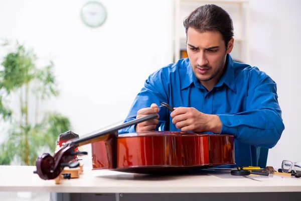 Jovem reparador do sexo masculino reparar violoncelo — Fotografia de Stock