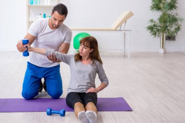 Kişisel koçla spor egzersizleri yapan genç bir kadın.