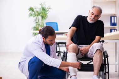 Yaşlı adam genç doktor travmatoloğu ziyaret ediyor.
