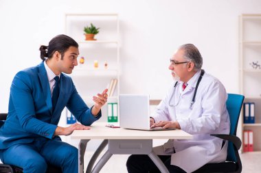 Genç işadamı yaşlı doktorla görüşüyor.