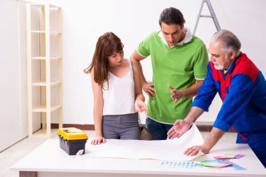 Genç çift ve ev yenileme konseptinde yaşlı müteahhit.