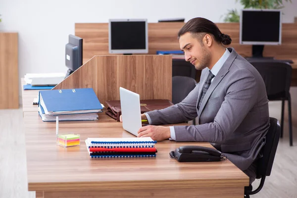 Joven empleado masculino infeliz con el trabajo excesivo — Foto de Stock