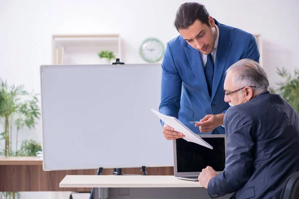 Yound and old employees in business presentation concept — Stock Photo, Image