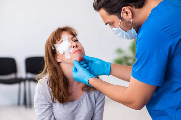 Jovem cabeça ferida mulher visitando jovem médico masculino — Fotografia de Stock