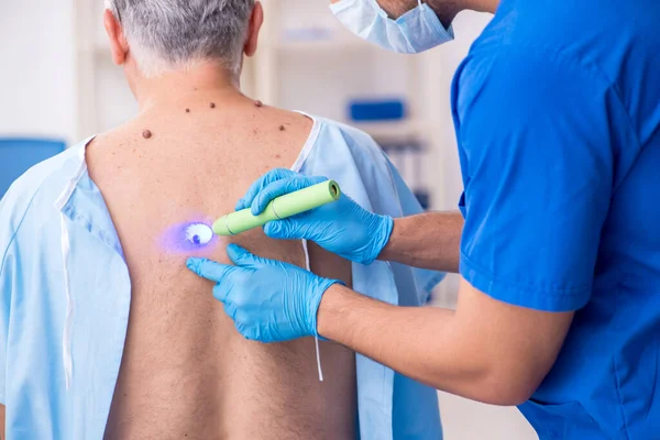 Viejo visitando joven médico dermatólogo — Foto de Stock