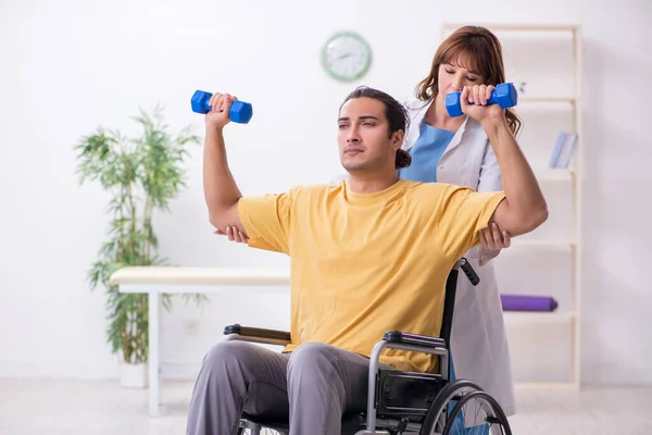 Joven paciente masculino en silla de ruedas haciendo ejercicios físicos — Foto de Stock