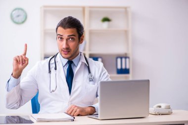 Klinikte çalışan yakışıklı genç bir doktor.