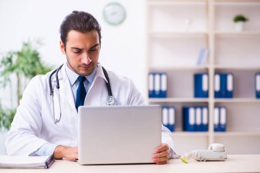 Klinikte çalışan yakışıklı genç bir doktor.