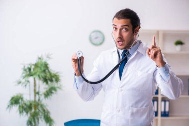 Klinikte çalışan yakışıklı genç bir doktor.