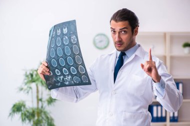 Klinikte çalışan yakışıklı genç bir doktor.