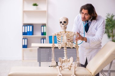 Deli doktor ölü hastayı muayene ediyor.