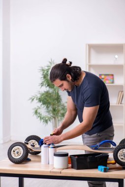 Kaykay tamir eden genç bir erkek tamirci.