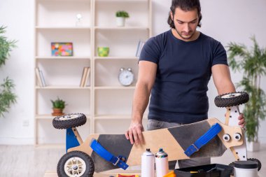 Kaykay tamir eden genç bir erkek tamirci.