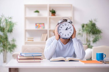 Evde sınava hazırlanan genç bir erkek öğrenci.