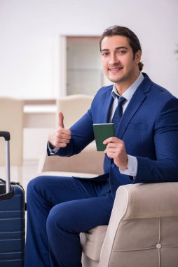 Pasaportlu genç işadamı seyahate hazırlanıyor.