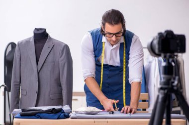 Genç erkek terzi blogu için video kaydediyor.
