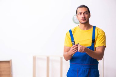 Genç erkek marangoz içeride çalışıyor.