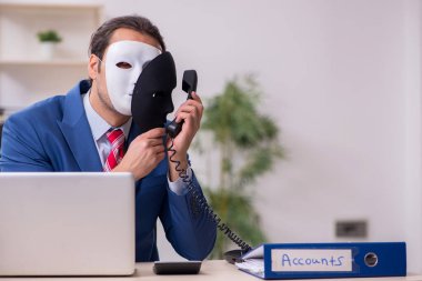 İkiyüzlülük konseptinde maske takan erkek çalışan.