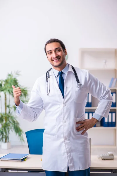 Mladý mužský pohledný lékař pracující na klinice — Stock fotografie