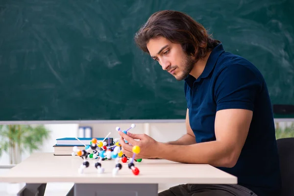 Jonge mannelijke wetenschapper zit in de klas — Stockfoto
