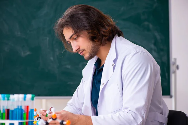 Joven científico masculino sentado en el aula — Foto de Stock