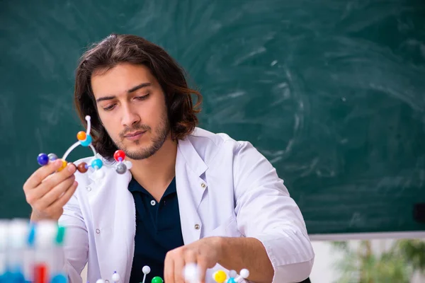 Giovane scienziato maschio seduto in classe — Foto Stock