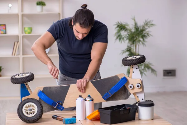 Young male repairman repairing skateboard