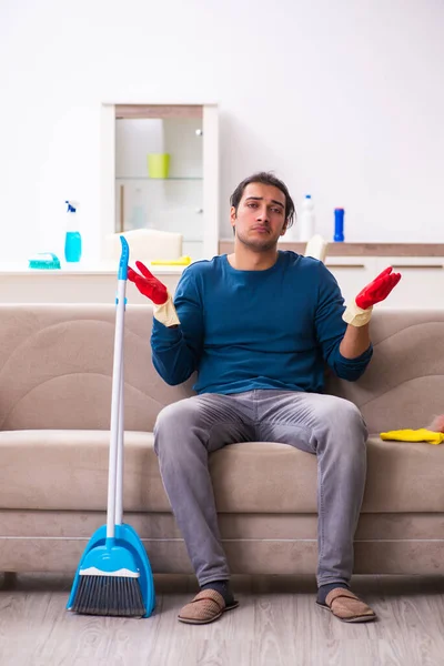 Jovem marido fazendo tarefas domésticas em casa — Fotografia de Stock