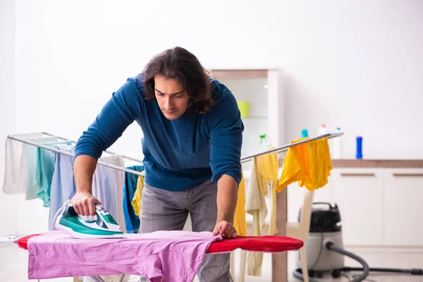 Mladý muž manžel dělá oblečení žehlení doma — Stock fotografie