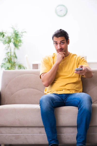 Hombre joven viendo la televisión en casa — Foto de Stock