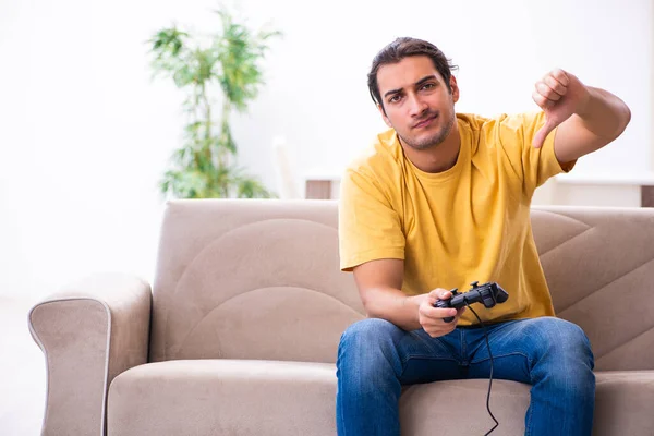 Jeune homme jouant à des jeux de joystick à la maison — Photo