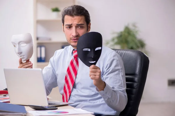 Mužský zaměstnanec s maskou v konceptu hipocrisy — Stock fotografie