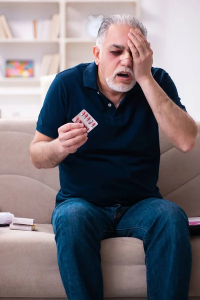 Old injured man in budget planning concept — Stock Photo, Image